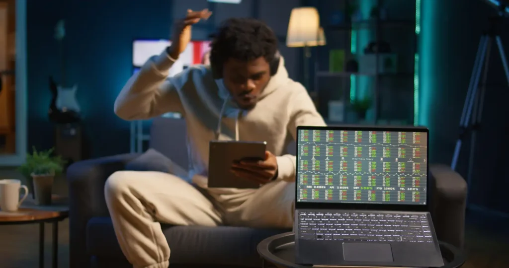 Homem assistindo a apostas de chutes a gol em um laptop, simbolizando emoções de apostas esportivas relacionadas a chutes a gol nas apostas